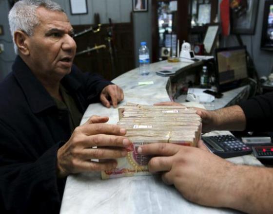 Iraq central bank devalues dinar as oil prices hurt income